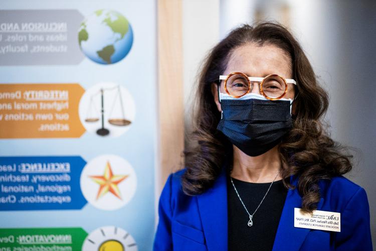 Sally Ellis Fletcher wearing a mask and standing near health sciences display