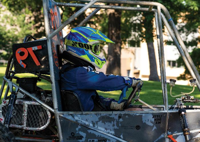 student with helmet in racing buggy