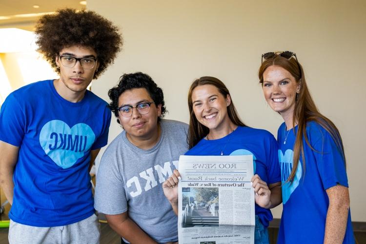 Roo News journalists smile holding their latest issue of Roo News