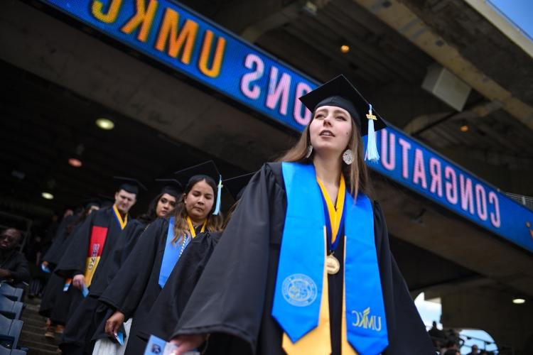 A line of graduates lining up in the stands of Kauffman Stadium