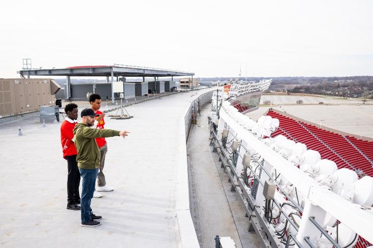 UMKC students on the roof of arrowhead stadium with their mentor of the day looking over the field  